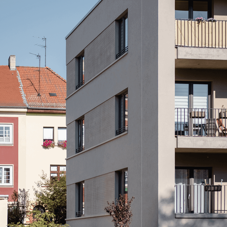 Modernes Mehrfamilienhaus mit grauer Putzfassade, Flachdach und Balkonen