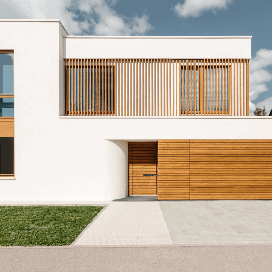 Modernes Einfamilienhaus mit weißer Putzfassade, Flachdach und Holzelementen in der Fassade